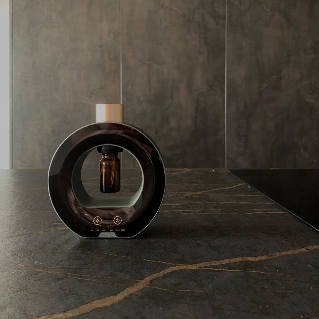 NASS Origin scent diffuser in black on a marble counter